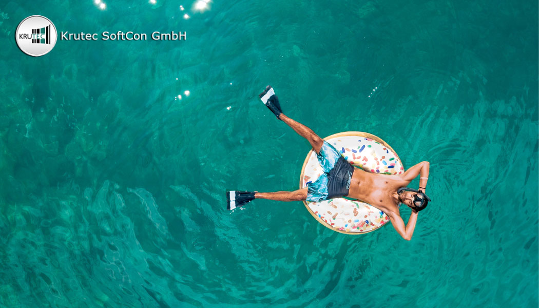 Mann mit Badehose und Schwimmflossen in einem Schwimmdonut, der auf dem Meer treibt