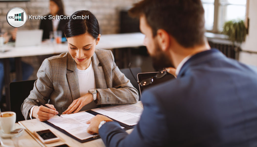 Frau sitzt ihrem zukünftigen Vorgesetzten gegenüber und unterschreibt einen befristeten Arbeitsvertrag